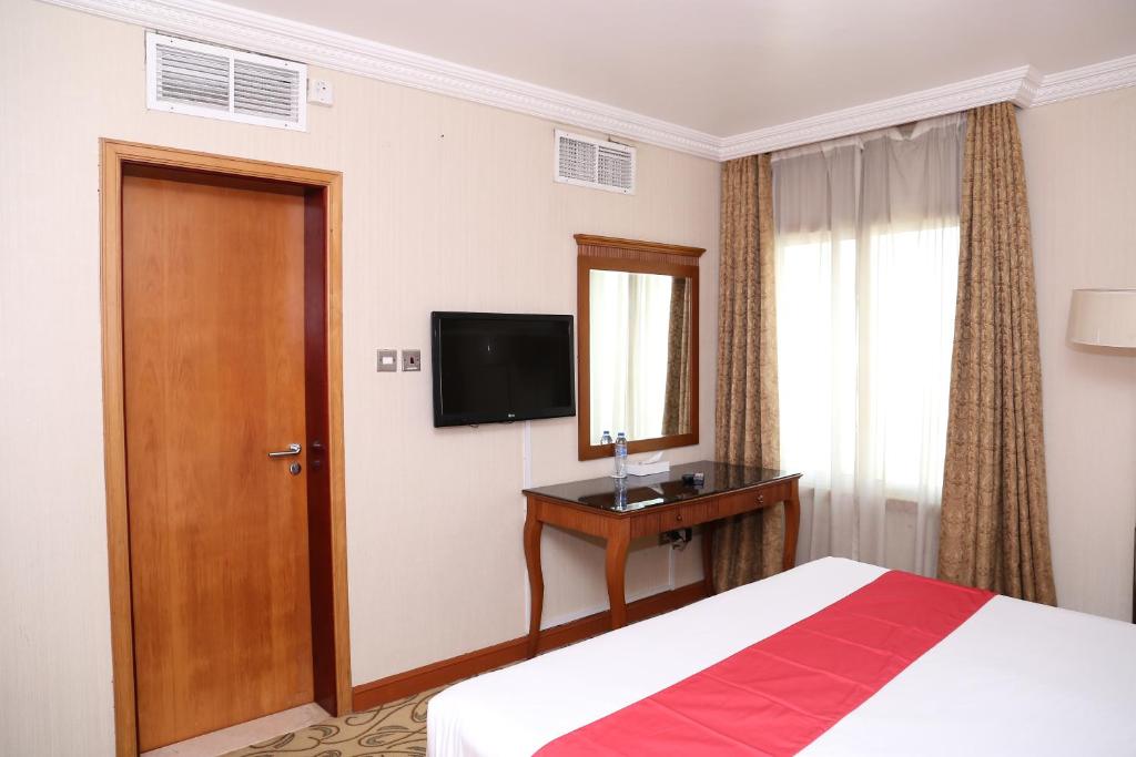 a hotel room with a bed and a television at City Plaza Hotel in Fujairah