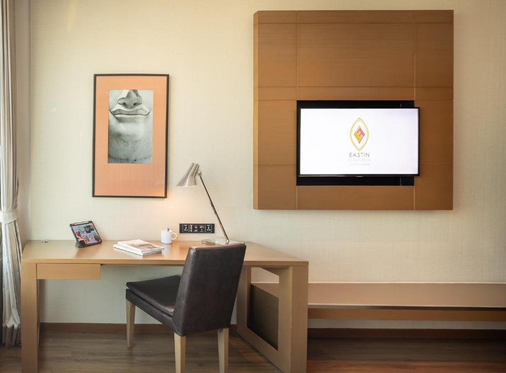 A dedicated hotel-room desk with television, lamp and built-in storage.