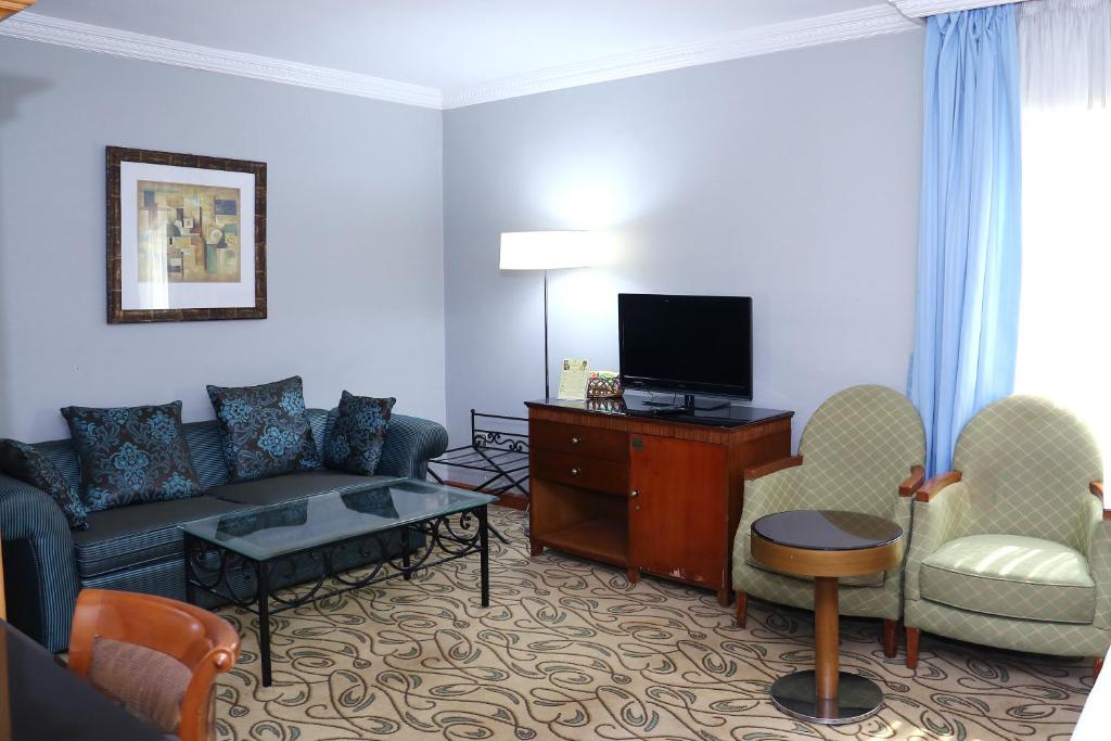 a living room with a couch and a tv at City Plaza Hotel in Fujairah