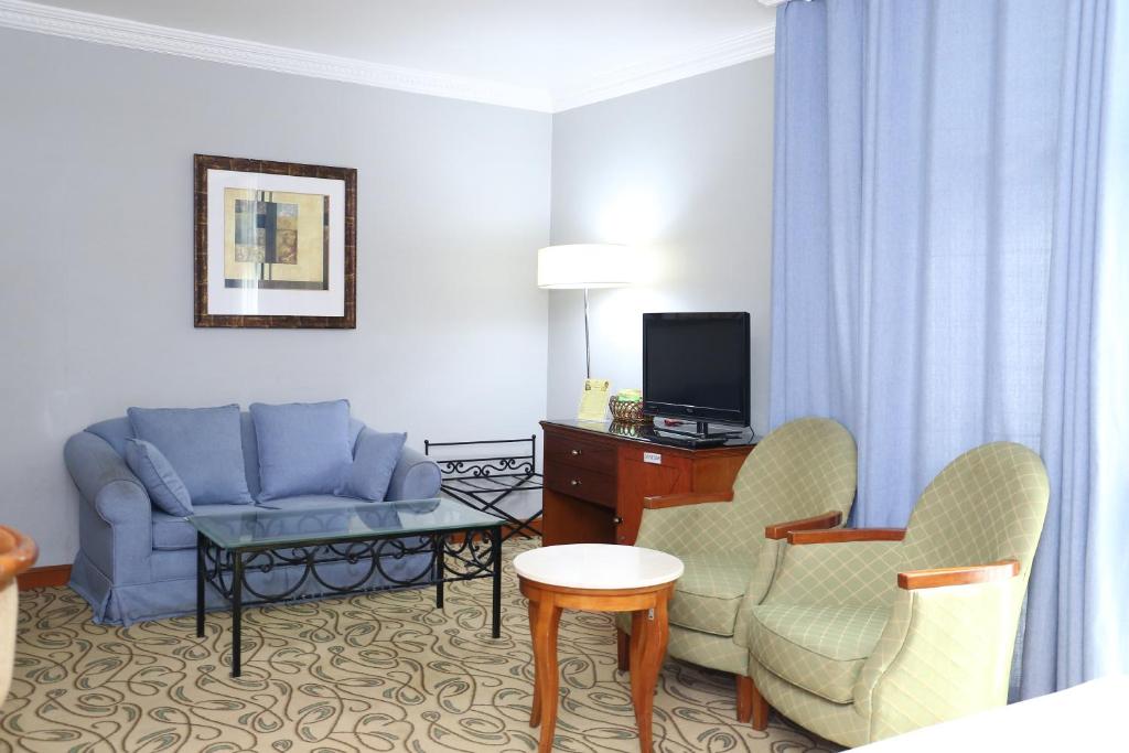 a living room with a couch and a tv at City Plaza Hotel in Fujairah