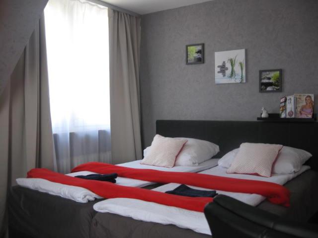 un grande letto con una coperta rossa e bianca sopra di Diamanthaus 2 Koblenz a Coblenza