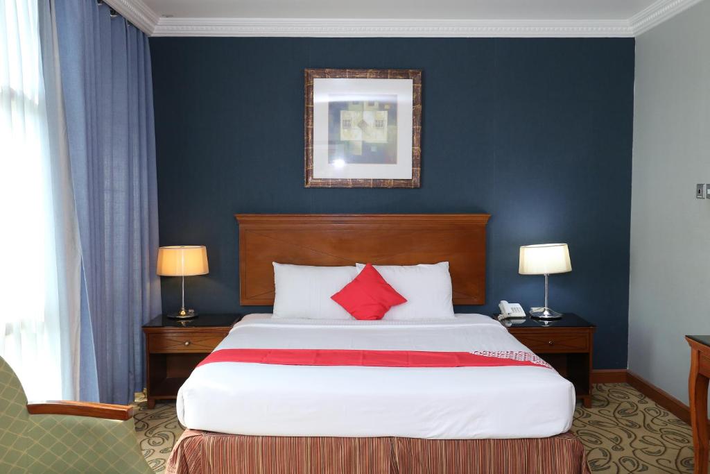 a bedroom with a large bed with red pillows at City Plaza Hotel in Fujairah