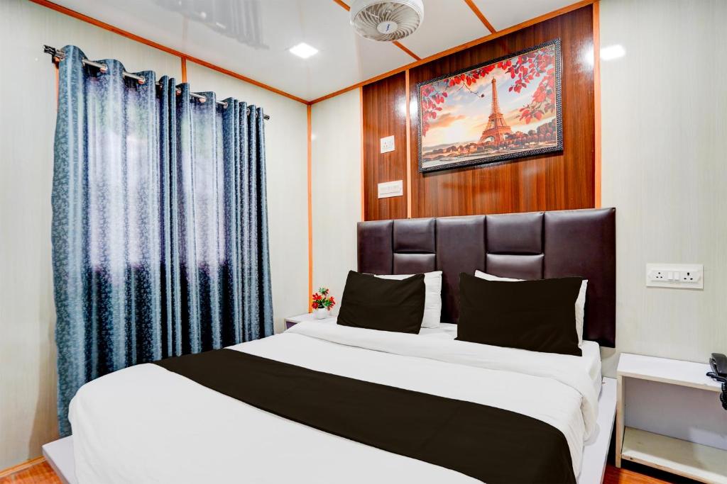 een slaapkamer met een groot wit bed en blauwe gordijnen bij OYO Jai Santoshi Dhaam in Vrindāvan