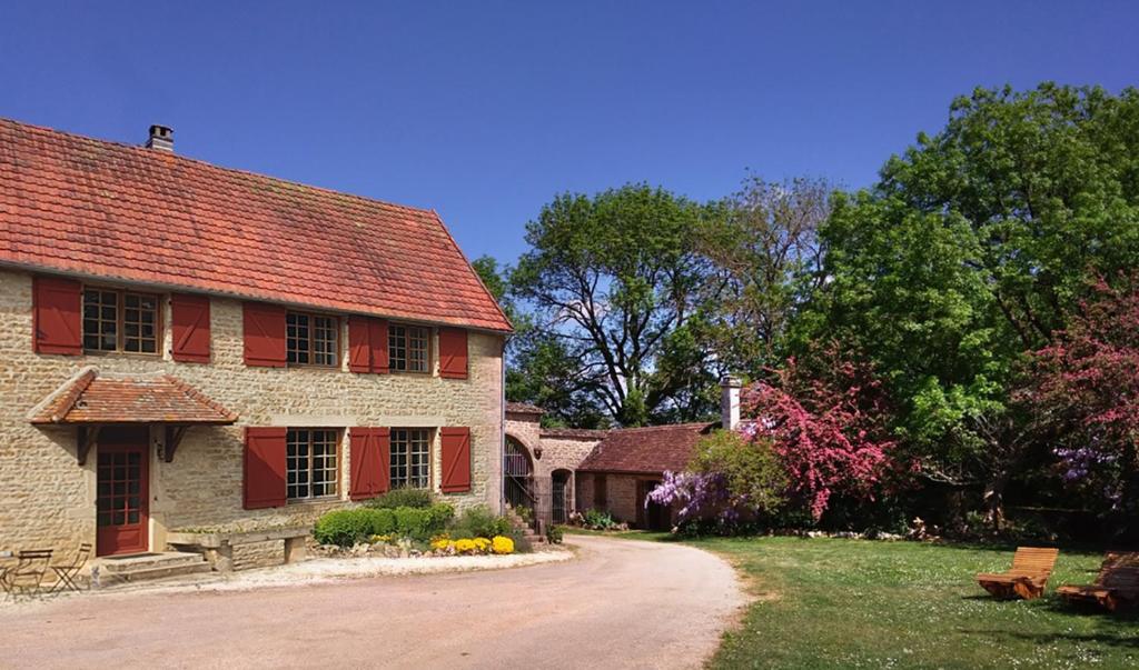une ancienne maison en briques avec des fenêtres rouges et un chemin de terre dans l'établissement Jardin des Sens, la Rente d'Eguilly, à Éguilly