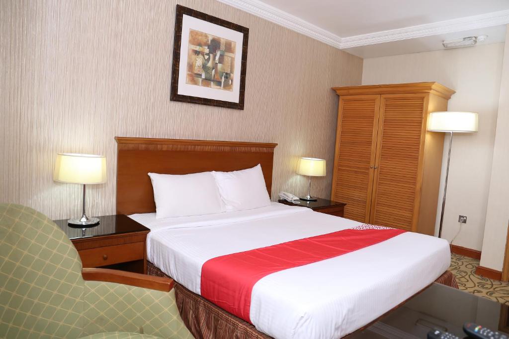 a hotel room with a large bed and two lamps at City Plaza Hotel in Fujairah