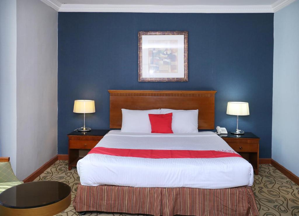 a bedroom with a large bed with red pillows at City Plaza Hotel in Fujairah