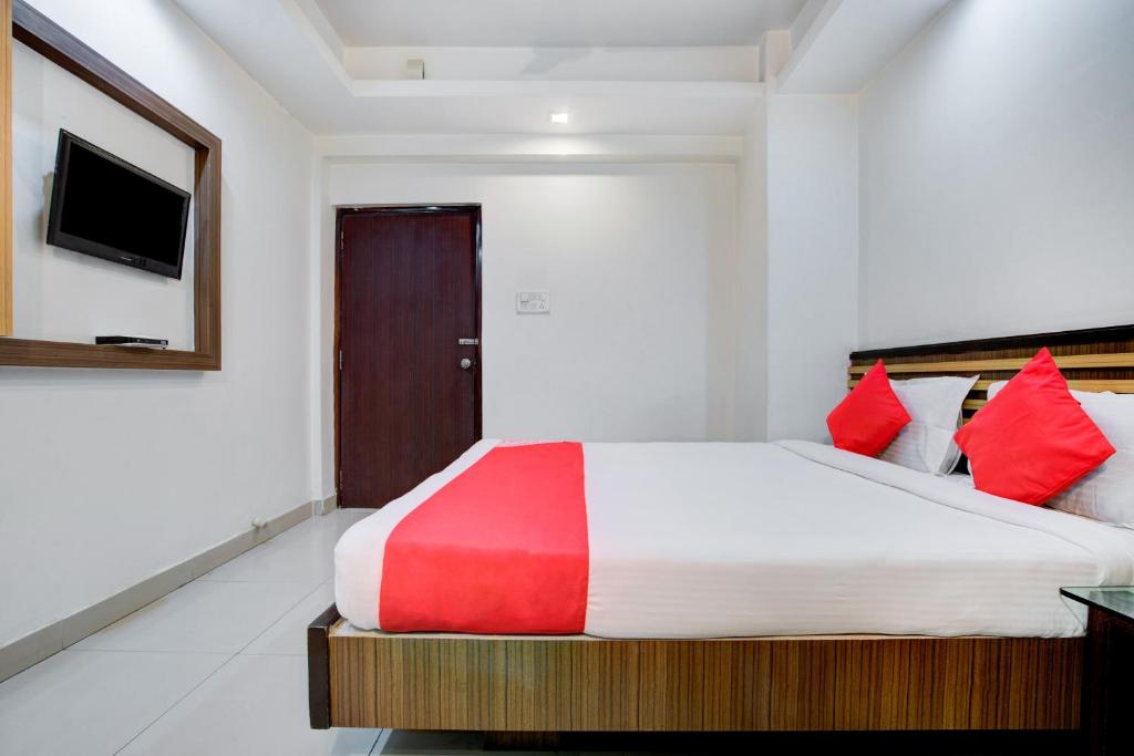 een slaapkamer met een groot bed met rode kussens bij OYO 7239 Hotel Aditya in Rānchī