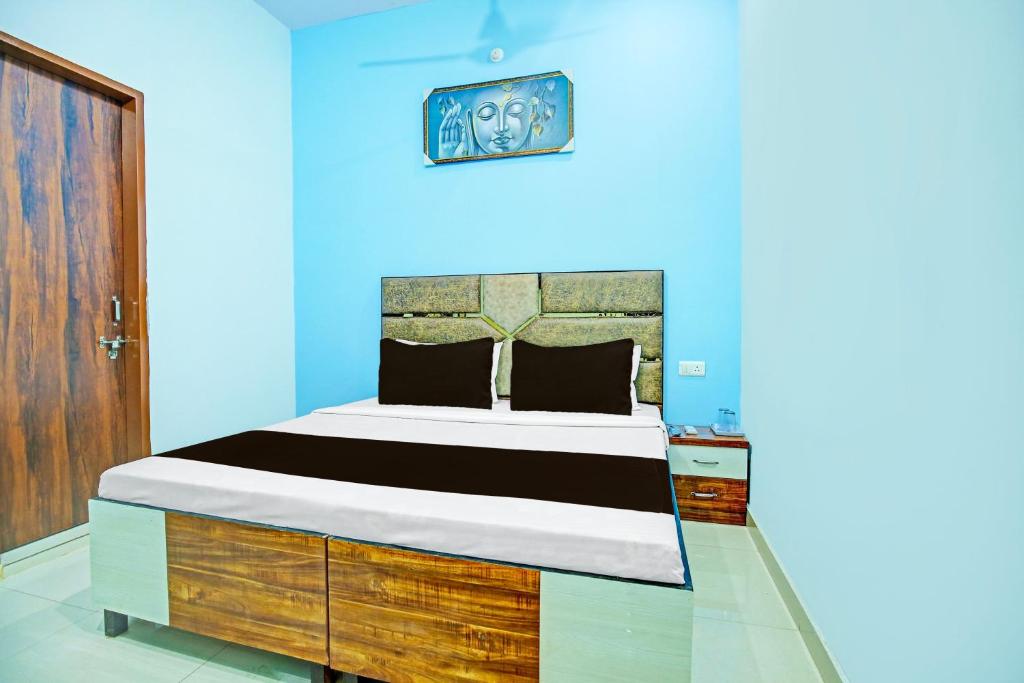 1 dormitorio con 1 cama grande y pared azul en OYO Sirsa Hotel & Guest House en Sirsa