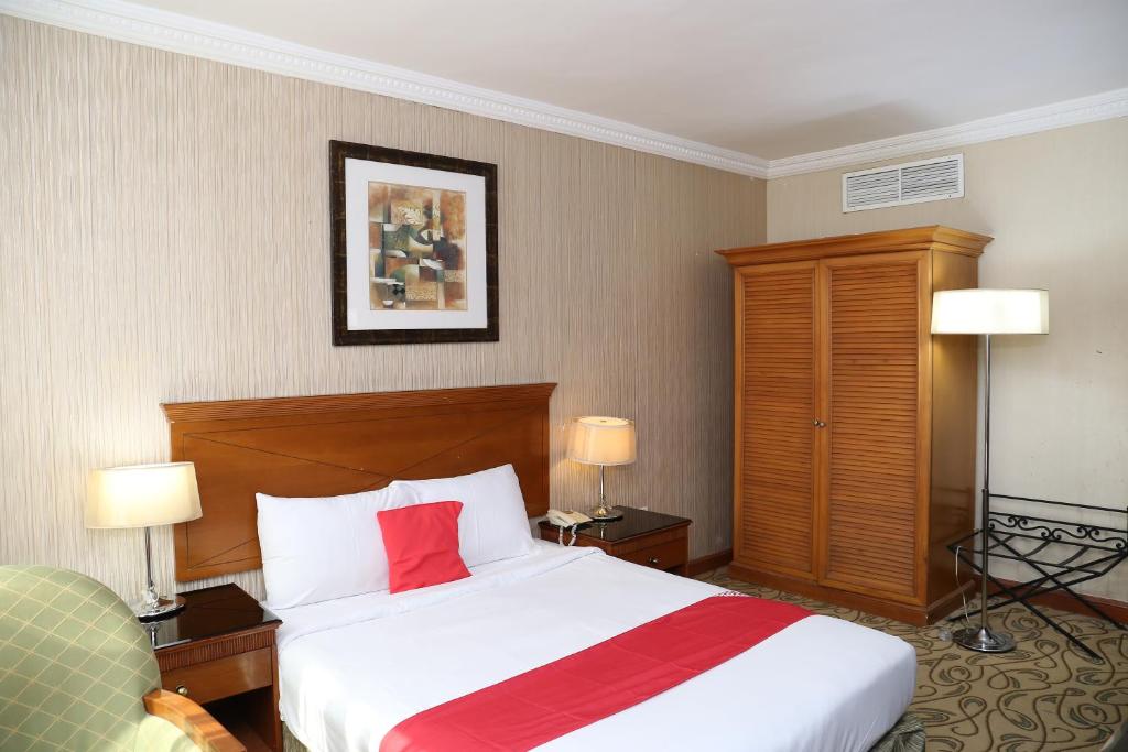 a hotel room with a bed with a red pillow at City Plaza Hotel in Fujairah