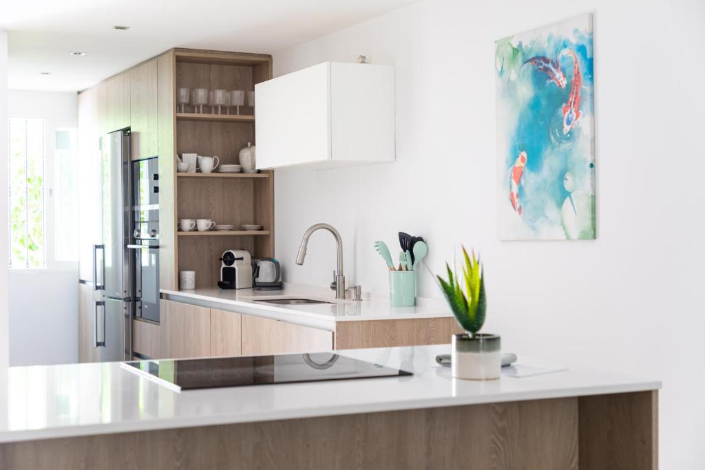 a kitchen with a sink and a refrigerator at AB Properties - Chic House Marbella - 3 mm to Puerto Banús and Beach - Golden Mile - Direct access to Pool and Tropical Garden in Marbella
