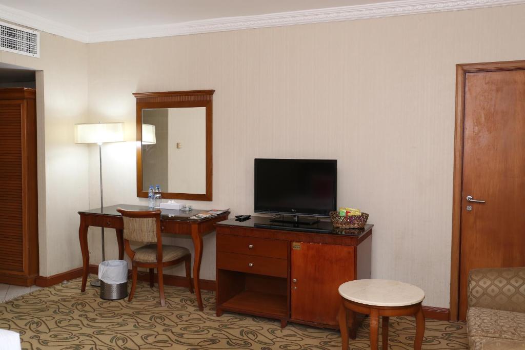 a hotel room with a desk with a television at City Plaza Hotel in Fujairah