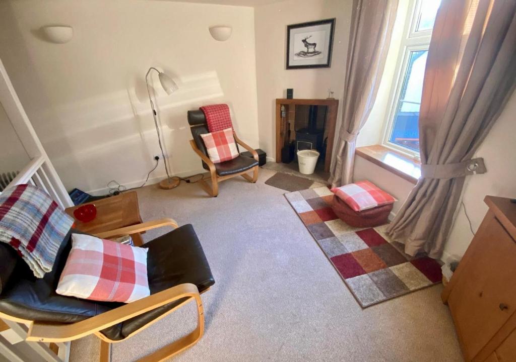 uma sala de estar com um sofá e cadeiras e uma janela em The Den em Lynmouth