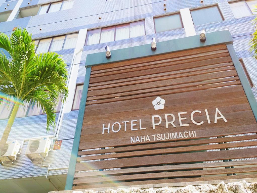 un panneau d'hôtel devant un bâtiment dans l'établissement Hotel Precia, à Naha