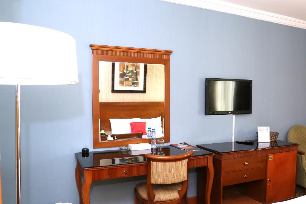 a hotel room with a desk and a mirror at City Plaza Hotel in Fujairah
