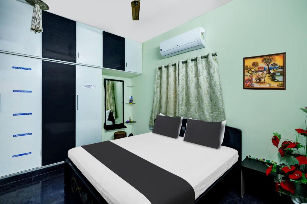 una camera con un letto bianco e nero di OYO SS Home Stay - An Unique Home Stay a Tirupati
