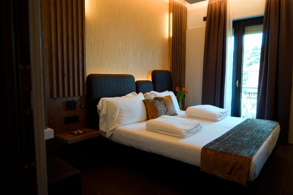 a hotel room with a bed with pillows and a window at Albergo Ristorante Papa in Peschiera del Garda