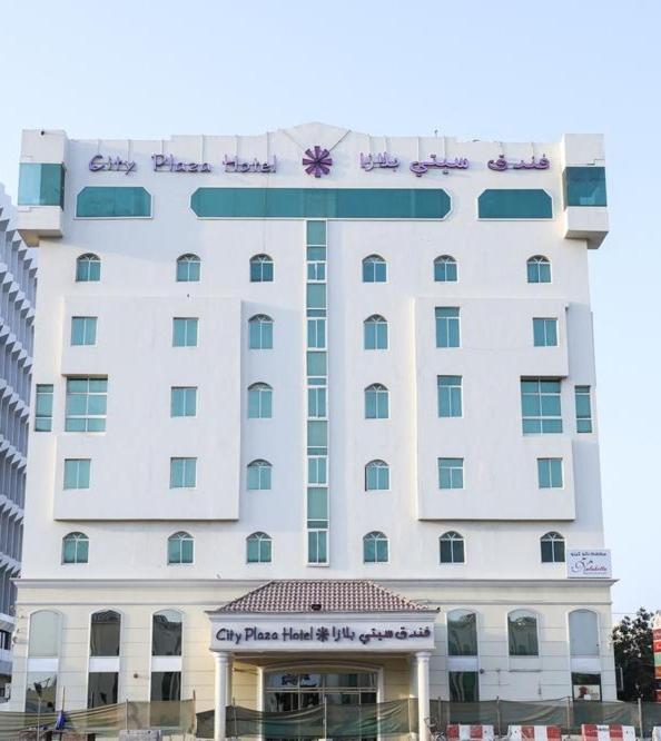 a large white building with a sign on it at City Plaza Hotel in Fujairah