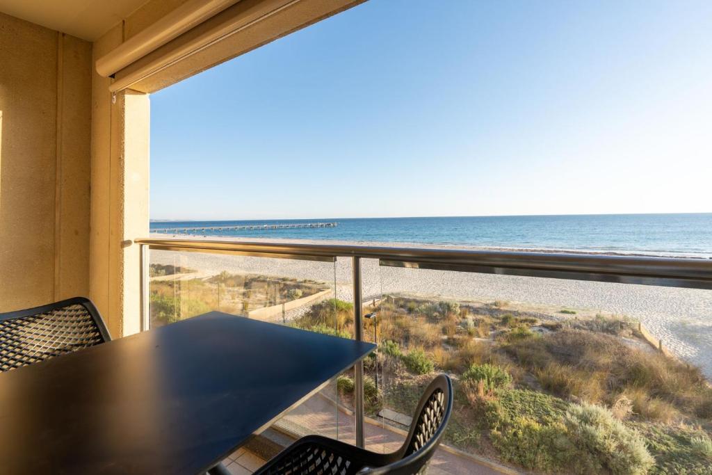 a view of the ocean from a table and chairs at Belle Escapes - Sunset Views at the Bay in Glenelg
