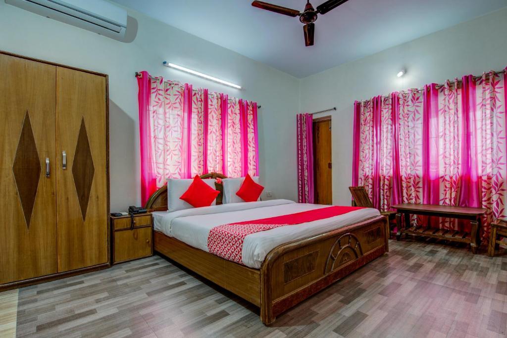 1 dormitorio con cama y cortinas rosas en OYO Flagship Corporate Club en Ranchi