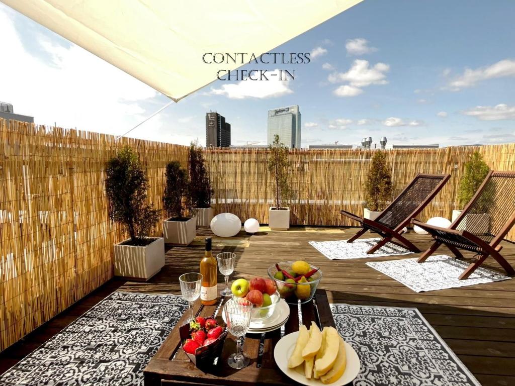 a patio with a table with fruit on a deck at City center flat w roof top terrace & free parking in Oslo