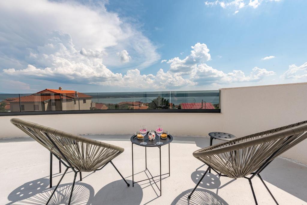 a patio with two chairs and a table on a roof at Master Road House in Maslenica
