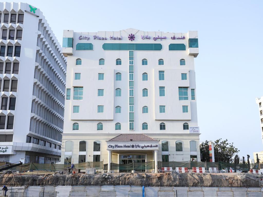a large white building with a sign on it at City Plaza Hotel in Fujairah