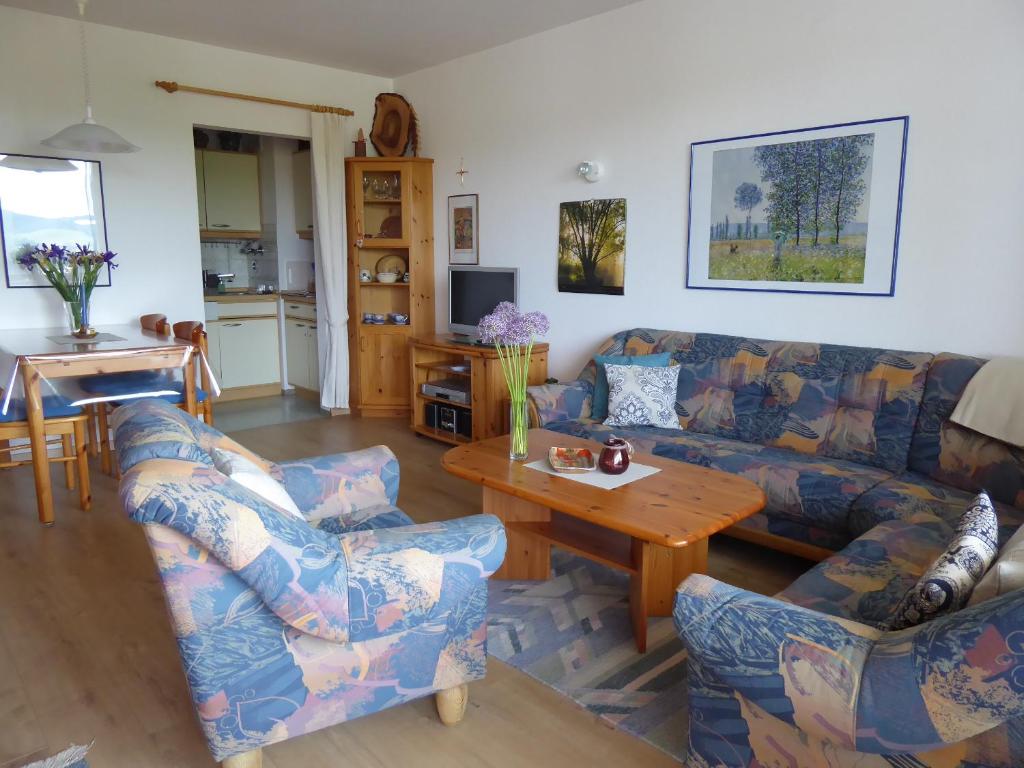 uma sala de estar com um sofá e uma mesa em Ferienwohnung Am Kräutergarten - mit Pool, Sauna und Garage em Missen-Wilhams