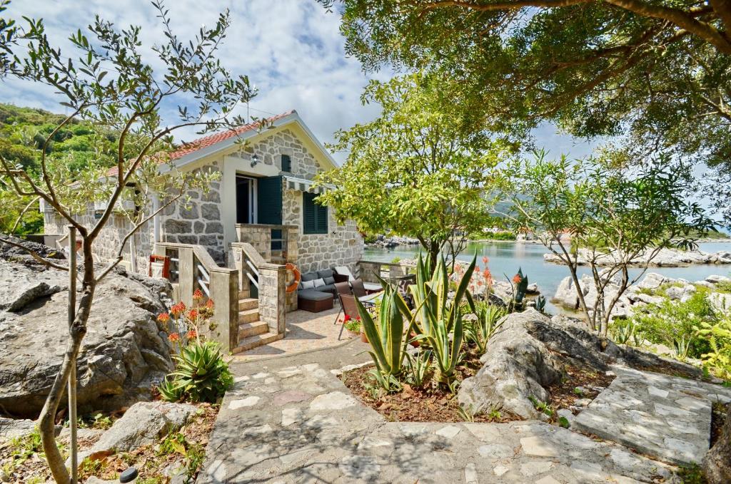 a stone house with a view of the water at Holiday Home Brinic in Tivat