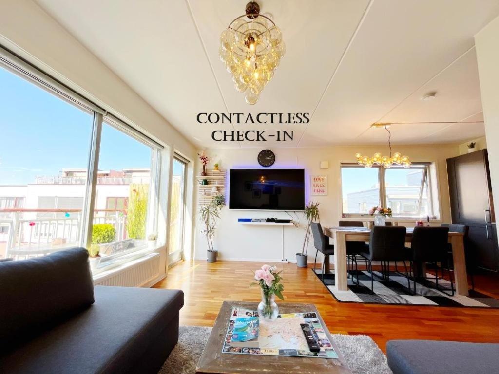 a living room with a dining table and a chandelier at Top floor city center flat with free parking in Oslo