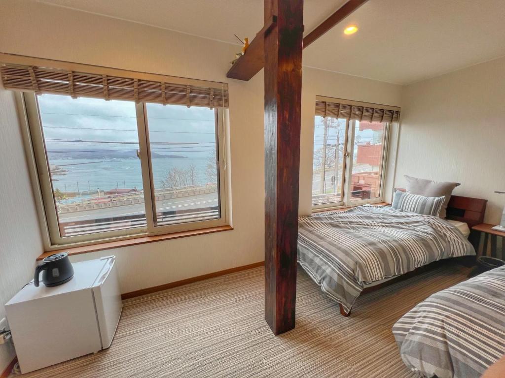 a bedroom with a bed and two windows at Populus-club Otaru - Vacation STAY 93434v in Otaru