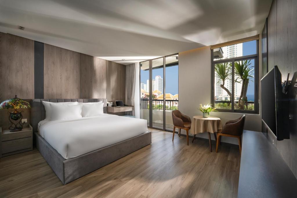 een hotelkamer met een bed en een groot raam bij Tashi Ocean Hotel & Apartment Da Nang in Da Nang