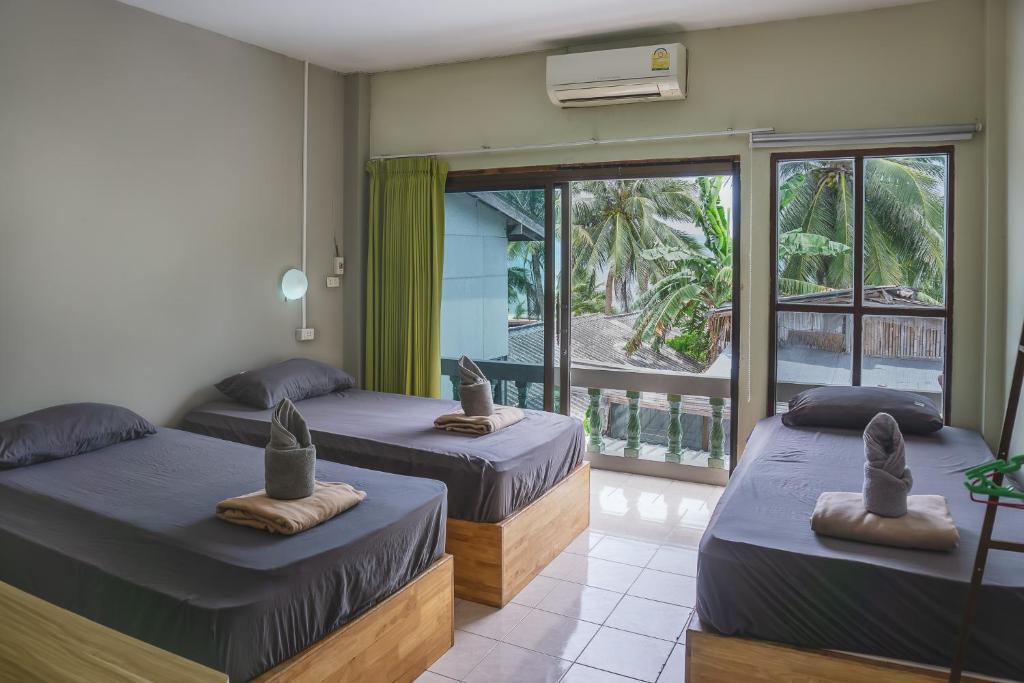 Habitación con 2 camas y balcón. en Echo Beach Hostel, en Baan Tai