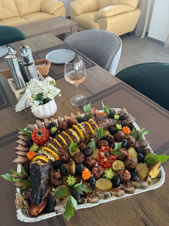 a platter of food on a wooden table at Pensiunea Taisia in Murighiol