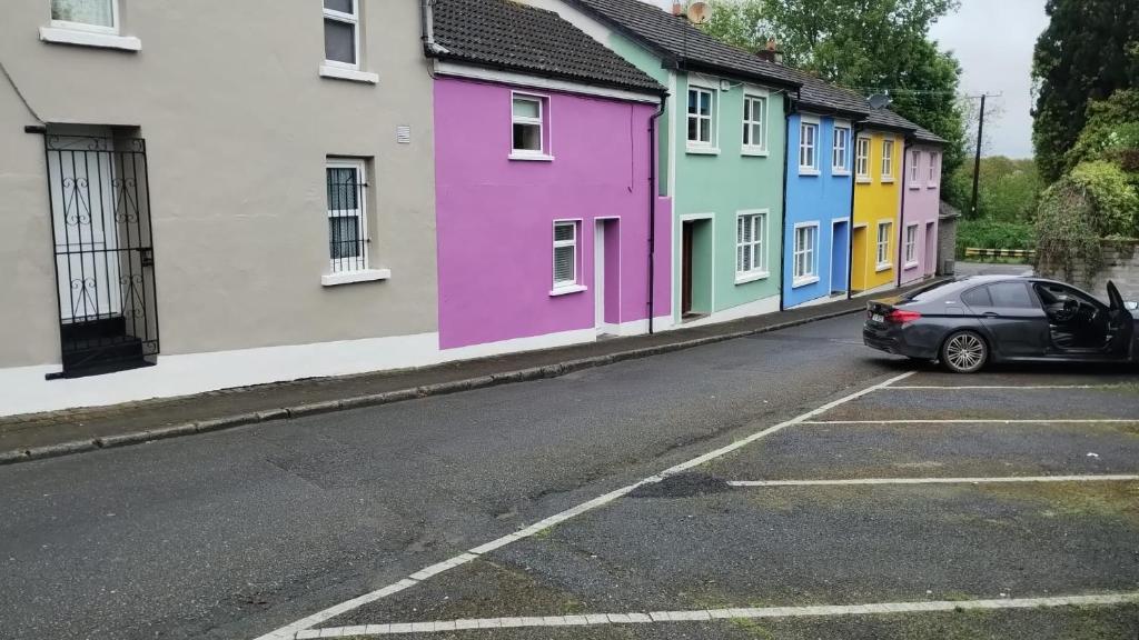 un coche aparcado frente a una fila de casas en Townhouse 2 Barrow Lane, en Carlow