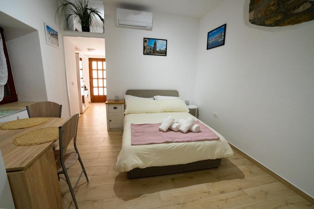 ein Schlafzimmer mit einem Bett mit einem Tisch und einem Esszimmer in der Unterkunft Studio GabAmi in Koper