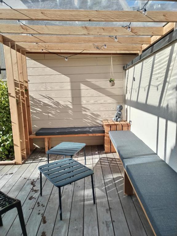 une terrasse avec un banc, une table et des chaises dans l'établissement Libération classé 3 étoiles, à Grandcamp-Maisy