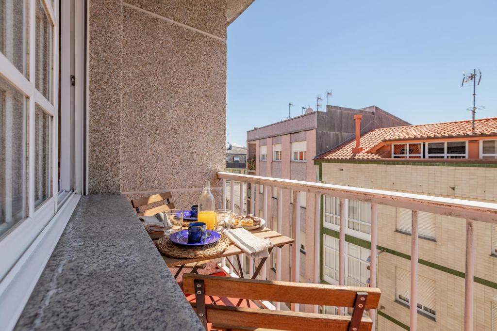 - Balcón con mesa y sillas en un edificio en Alojamientos Rías Baixas - Casa Lisi - Ribeira en Ribeira