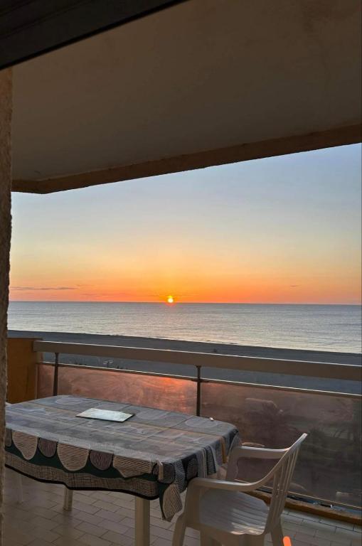 d'une table et de chaises sur un balcon avec vue sur le coucher du soleil. dans l'établissement Les sablines, à Canet