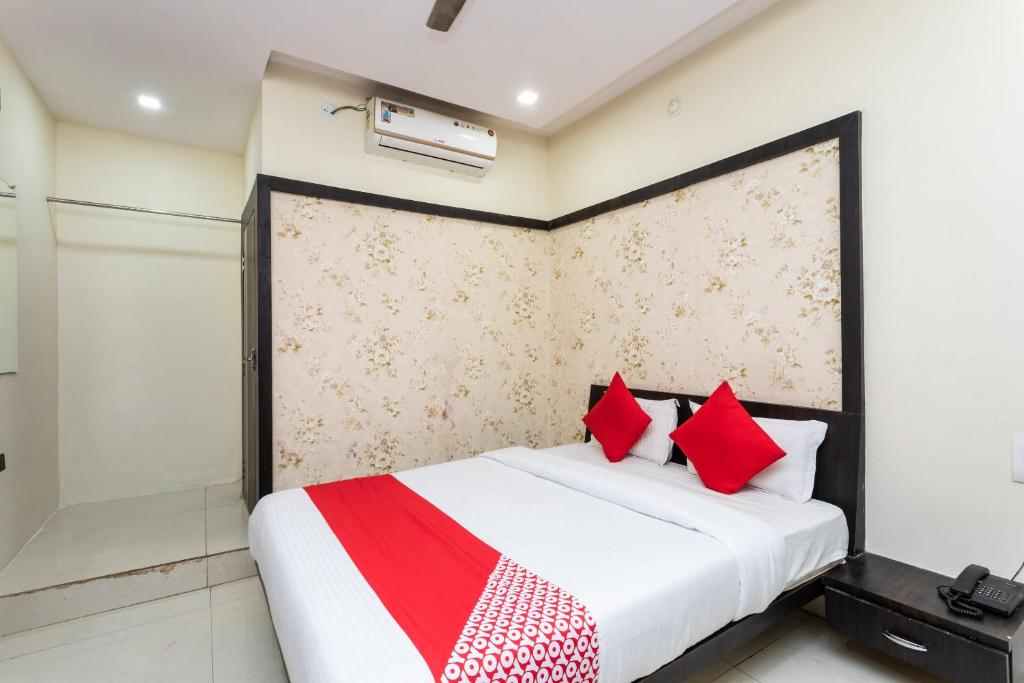 a bedroom with a bed with red pillows at OYO Sun Palace in Jabalpur