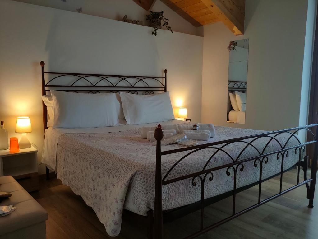 1 dormitorio con 1 cama grande con almohadas blancas en Arduino41, en San Martino Canavese