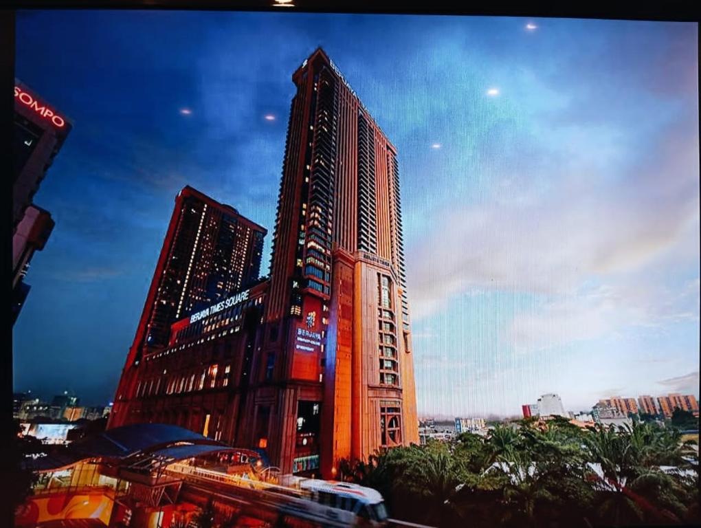 un edificio alto con un tren delante de él en First service suite KL Berjaya times Square, en Kuala Lumpur