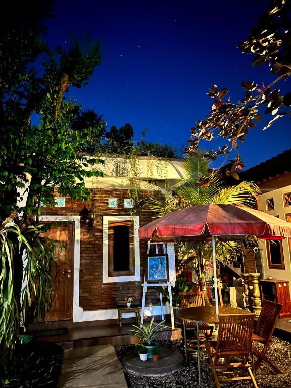 a house with a table and chairs and an umbrella at Rumah Pathuk Syariah Homestay in Yogyakarta