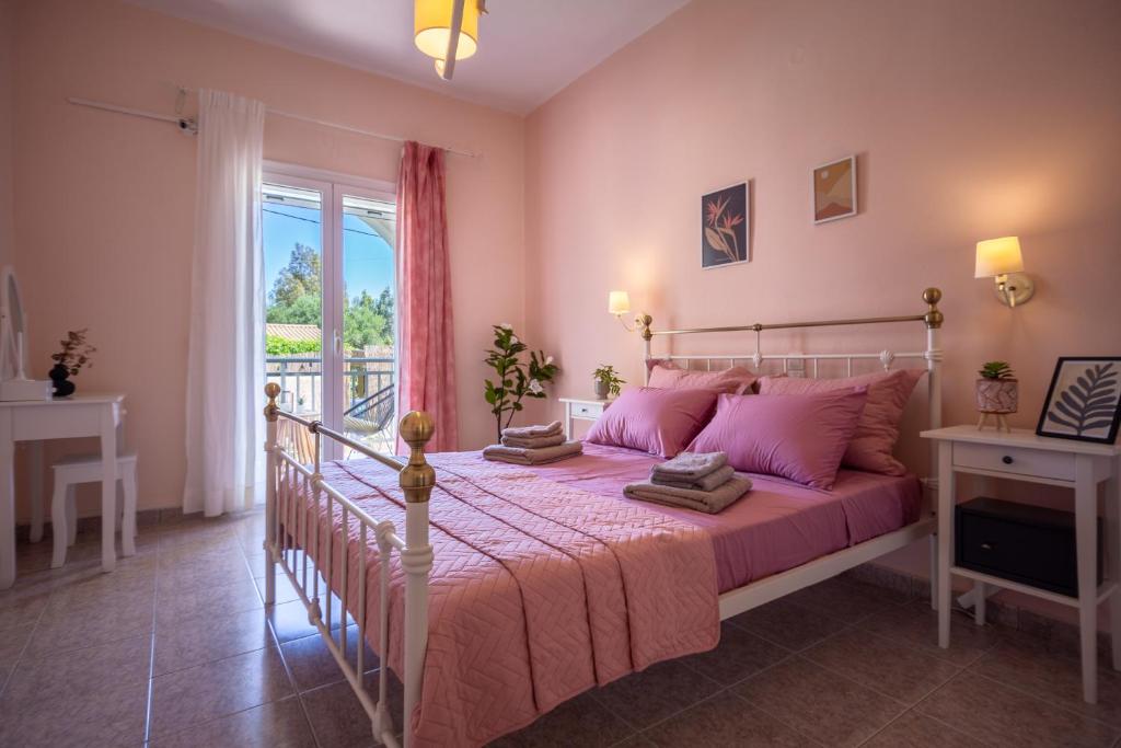 1 dormitorio con cama con sábanas rosas y ventana en Royal Jelly Suites - Renovated Suites with Pool Just 5 Minutes walk from the Beach By Villa Mana Gers, en Marathias