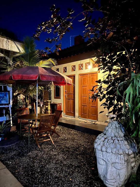 a house with a table and chairs and an umbrella at Rumah Pathuk Syariah Homestay in Yogyakarta
