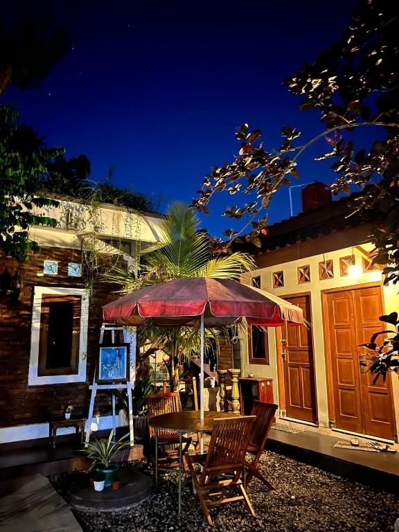 a table with an umbrella in front of a house at Rumah Pathuk Syariah Homestay in Yogyakarta