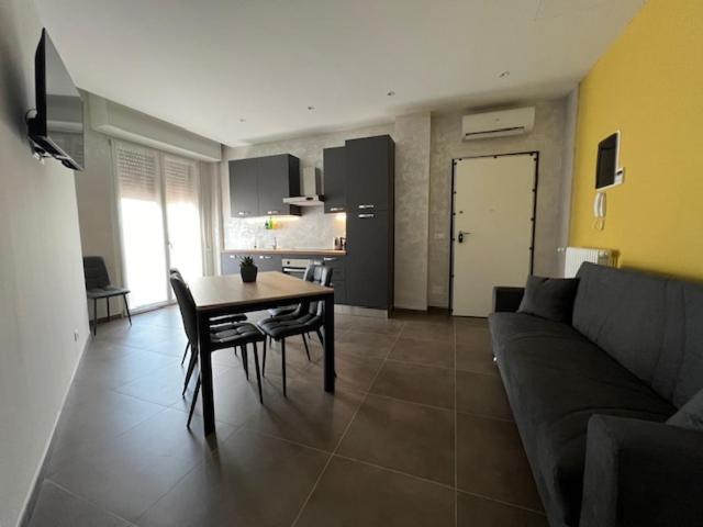 un soggiorno con divano e tavolo e una cucina di Brunello Apartment a Mantova