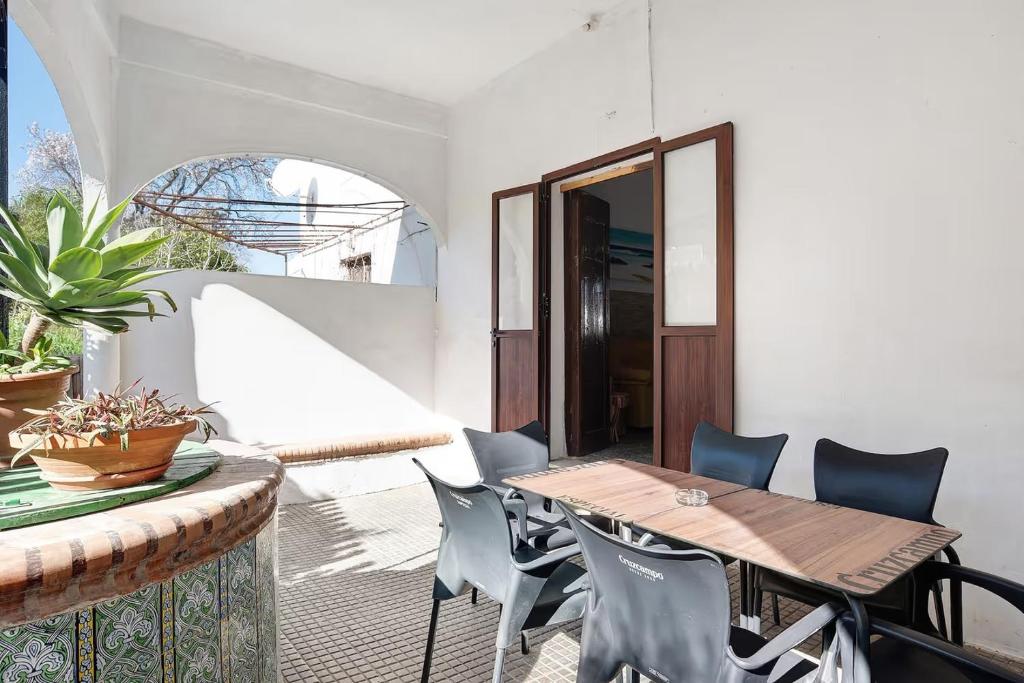een patio met een houten tafel en stoelen bij Casa Rural Cruce de Castro in Cádiz