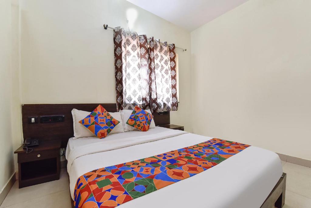 a bedroom with a large bed and a window at FabExpress Clausil Inn in Taleigao