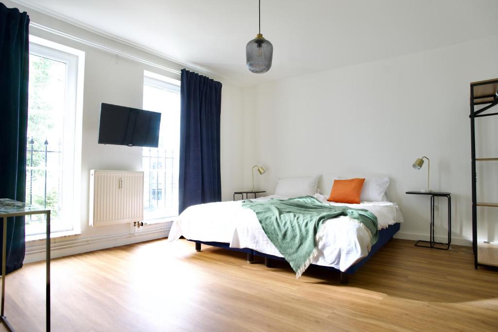 a bedroom with a bed and a large window at Apartments Les Jardins in Hamburg