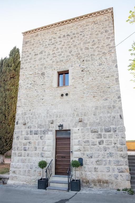 a stone building with a door and a window at LA TORRE DELLA RIPA in Tarquinia